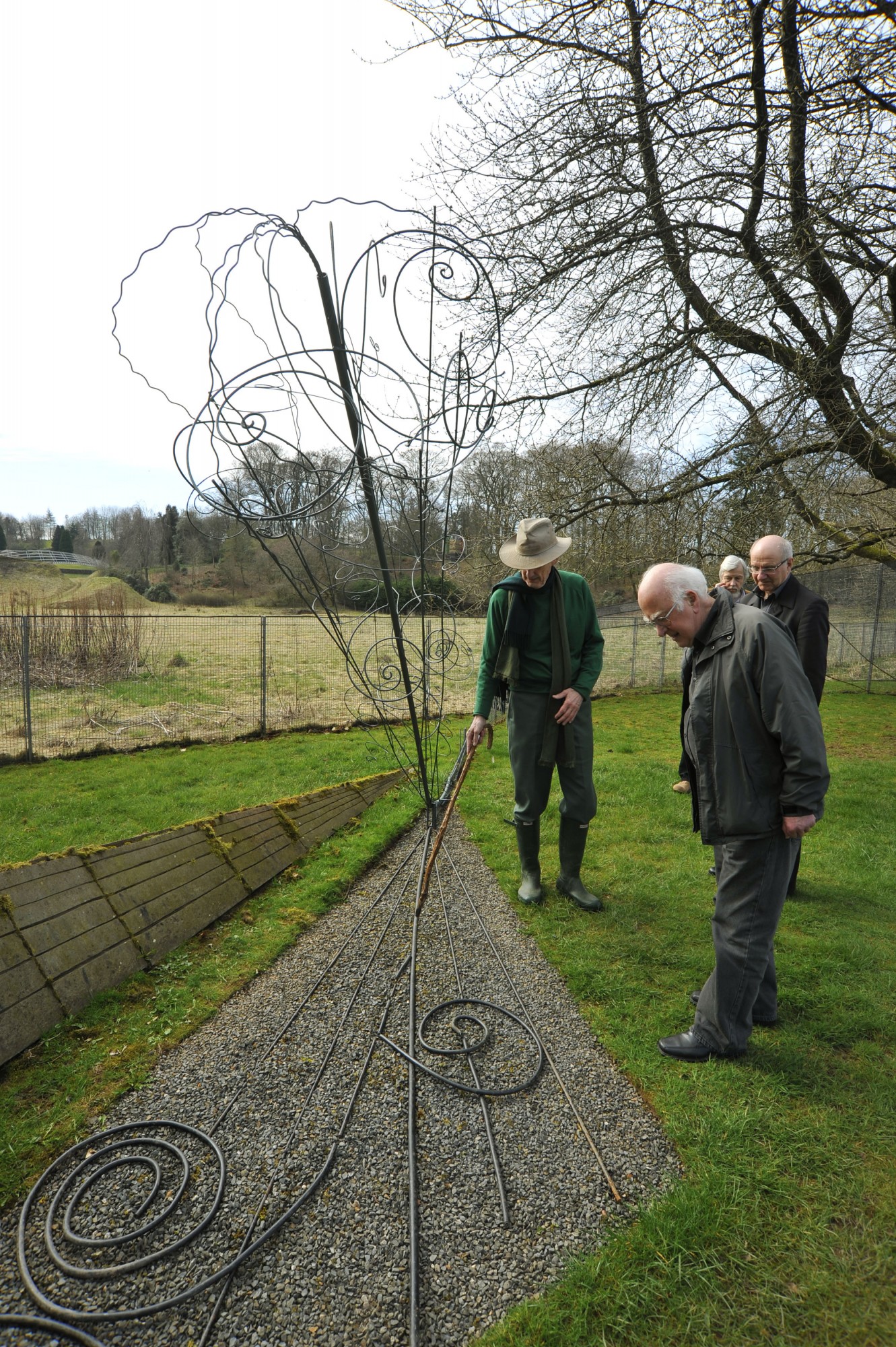 Peter Higgs and Charles Jencks admiring the bubble chamber tracks sculpture. In the background are Alan Walker and Rolf Heuer