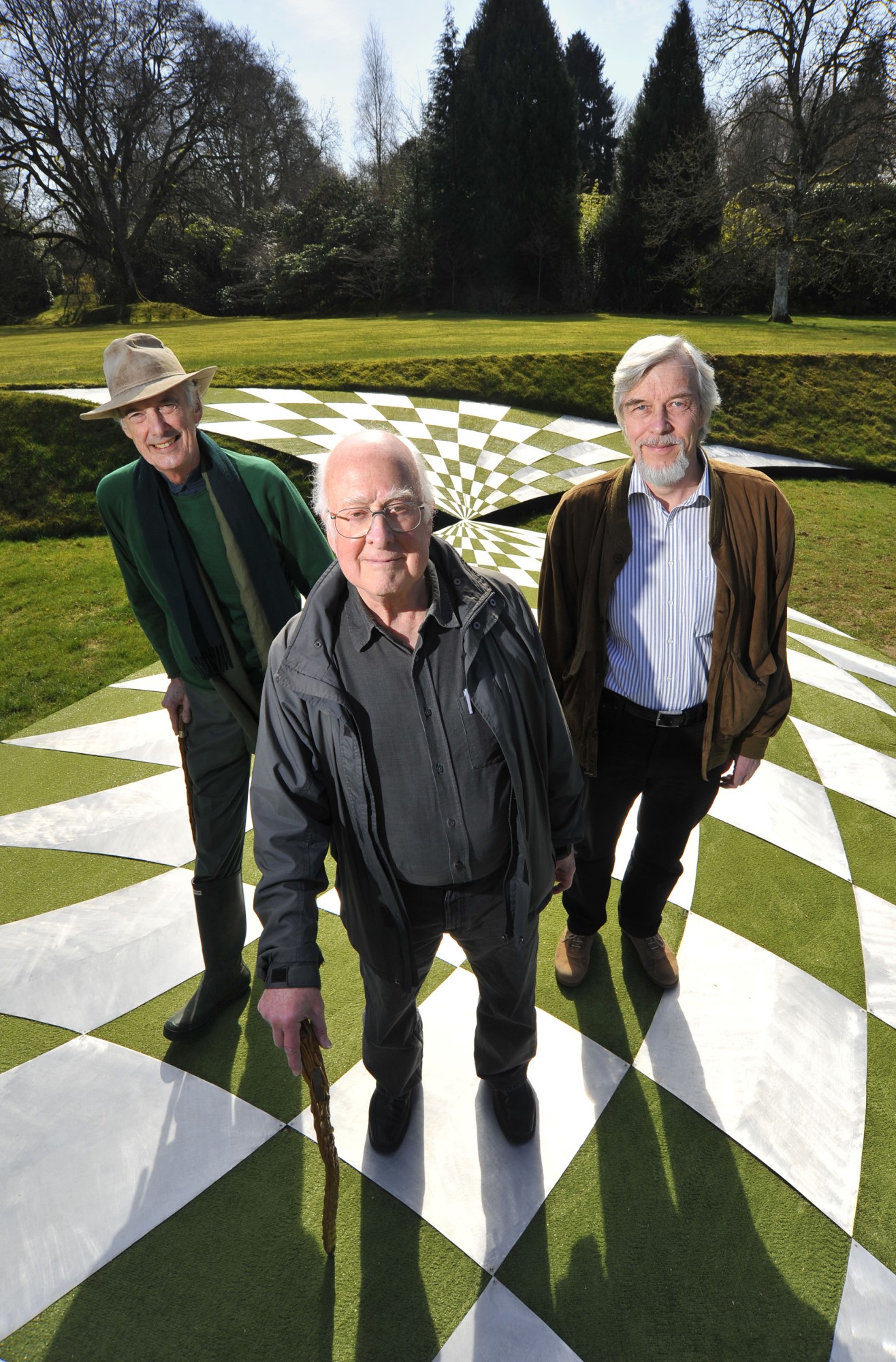 Left to right: Charles Jencks, Peter Higgs and Rolf Heuer standing on Charles&#039; representation of space-time in the vicinity of a black hole