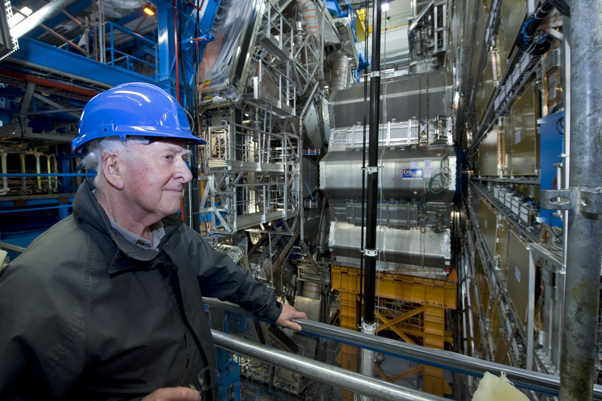 Peter Higgs in front of one of the ATLAS end cap toroidal magnets on his visit to the ATLAS cavern. Photograph copyright Claudia Marcelloni, ATLAS &amp; CERN.