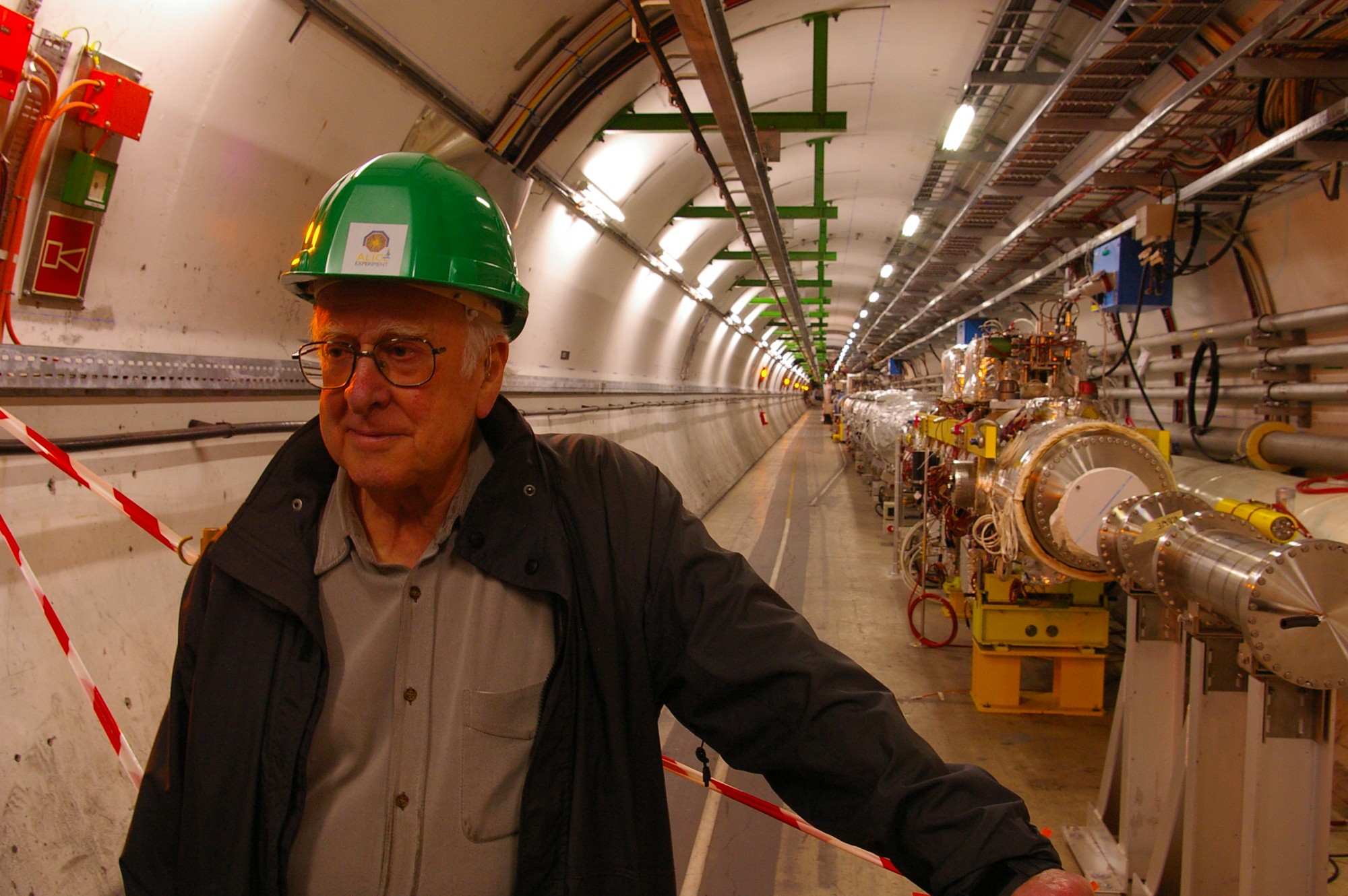 Peter Higgs in the long straight section of the Large Hadron Collider tunnel, just before the underground ALICE experimental hall. Photograph copyright Alan Walker, University of Edinburgh.